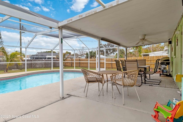 view of swimming pool with glass enclosure, grilling area, ceiling fan, and a patio