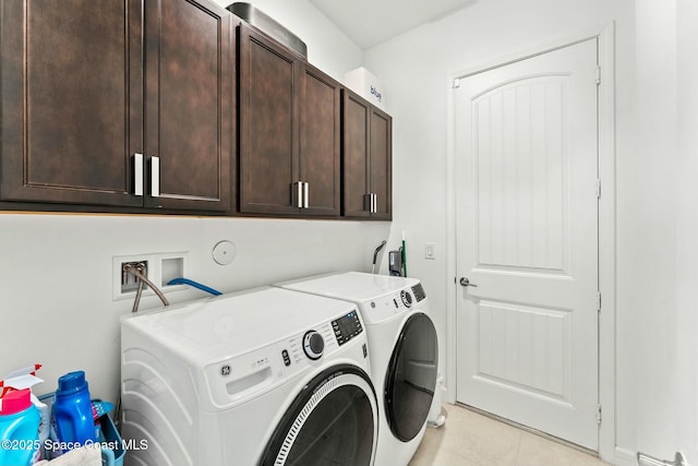 washroom featuring washer and clothes dryer, light tile patterned floors, and cabinets