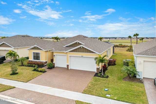 ranch-style home with a garage and a front lawn