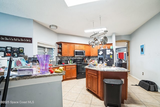 kitchen with stainless steel appliances, light tile patterned flooring, tasteful backsplash, and a center island