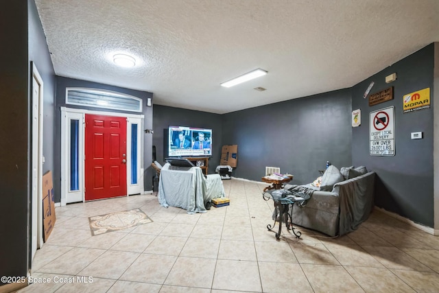 entrance foyer with a textured ceiling and light tile patterned floors