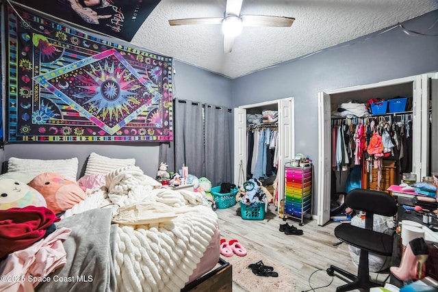 bedroom with a textured ceiling, ceiling fan, and wood-type flooring