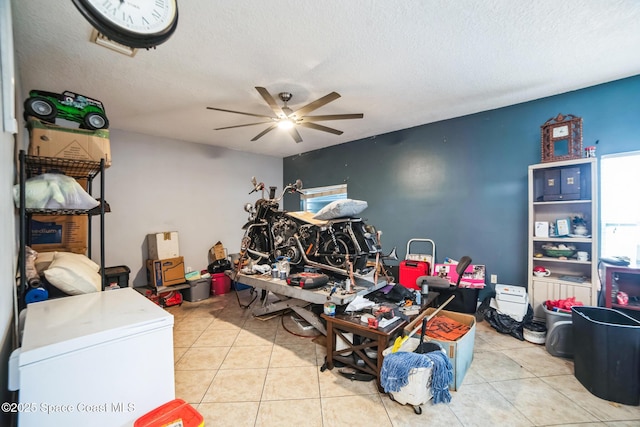 miscellaneous room with light tile patterned flooring, a textured ceiling, and ceiling fan