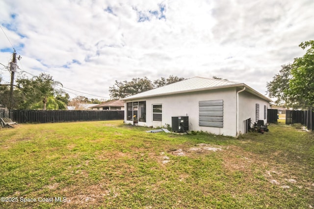 rear view of property with a lawn and central AC