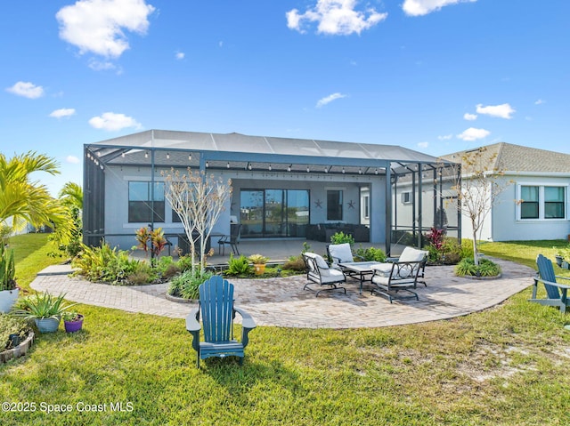 back of property with glass enclosure, a yard, and a patio