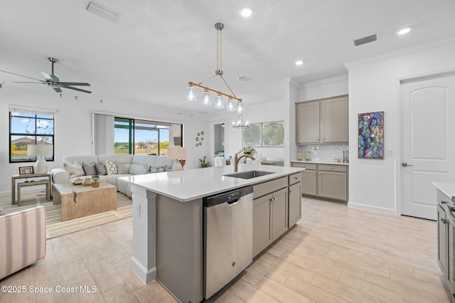 kitchen featuring decorative backsplash, a kitchen island with sink, decorative light fixtures, stainless steel dishwasher, and sink