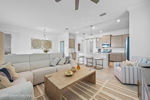 living room featuring ornamental molding and ceiling fan with notable chandelier