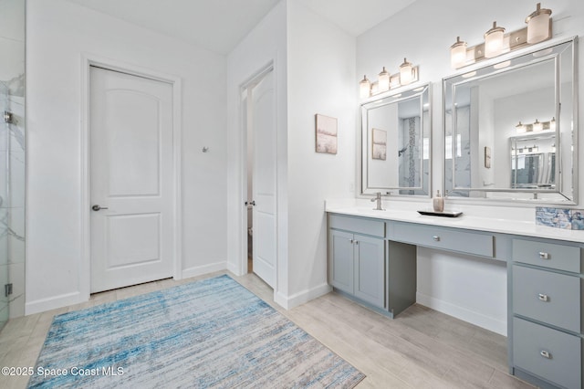 bathroom featuring a shower with shower door, wood-type flooring, and vanity