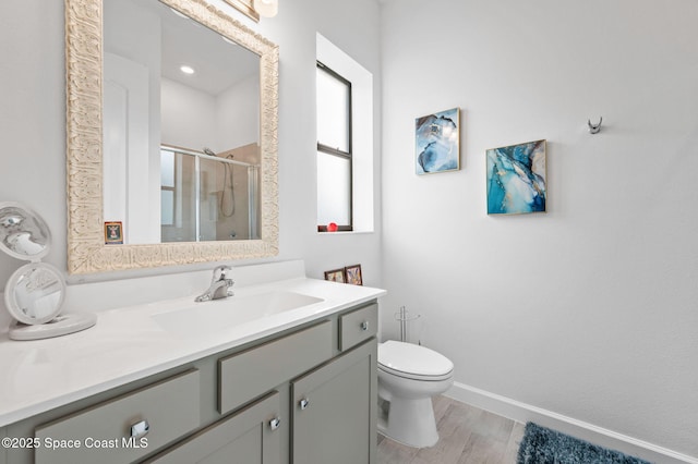 bathroom with toilet, vanity, walk in shower, and hardwood / wood-style flooring