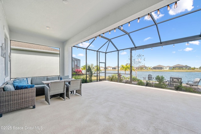 view of patio with glass enclosure, an outdoor living space, and a water view