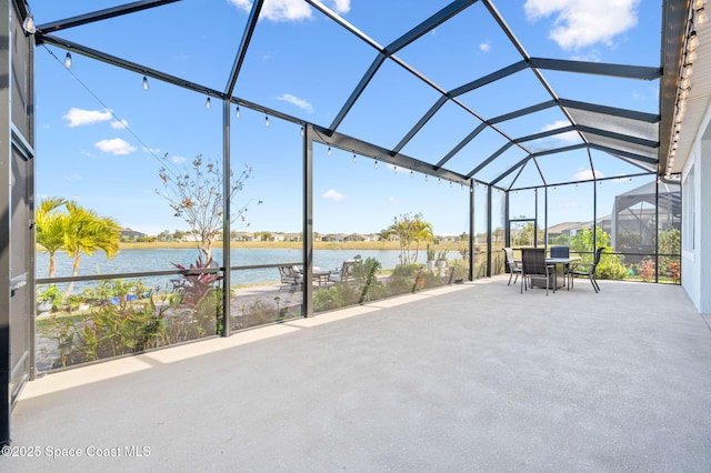 view of patio with glass enclosure and a water view