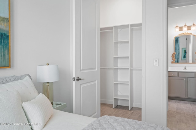 bedroom featuring light wood-type flooring, a closet, and connected bathroom