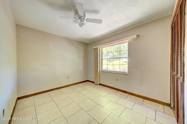 tiled spare room featuring ceiling fan and a textured ceiling