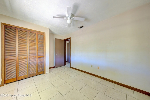 unfurnished bedroom with ceiling fan and a closet