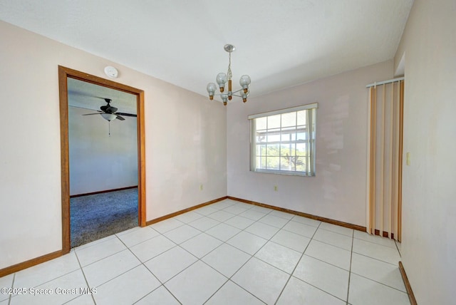 empty room featuring ceiling fan with notable chandelier and light tile patterned floors