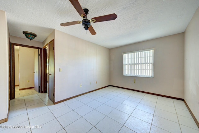 tiled empty room featuring a textured ceiling and ceiling fan