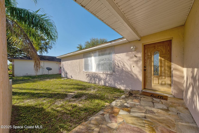 doorway to property with a yard