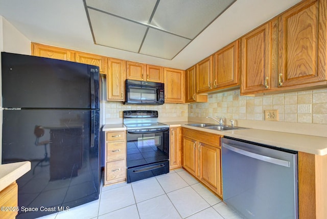 kitchen featuring backsplash, light tile patterned flooring, black appliances, and sink