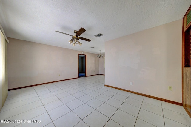 tiled spare room featuring a textured ceiling and ceiling fan with notable chandelier