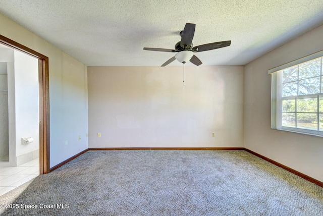 empty room with a textured ceiling, light carpet, and ceiling fan