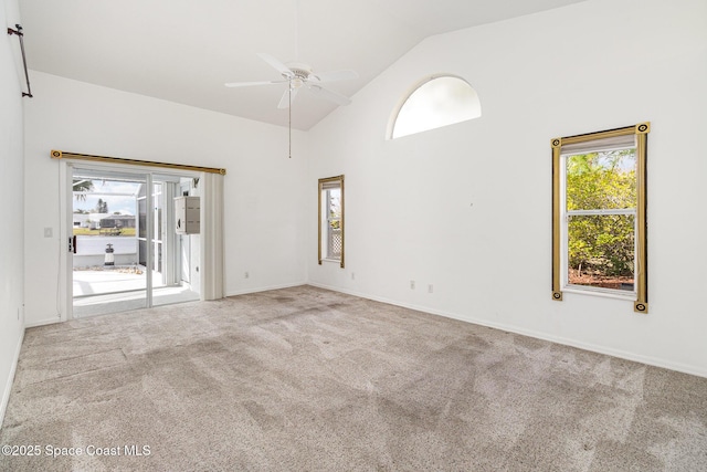 carpeted empty room featuring ceiling fan, a healthy amount of sunlight, and high vaulted ceiling