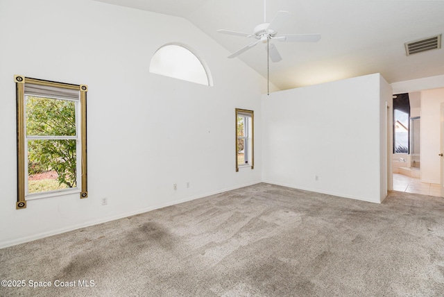 carpeted spare room with ceiling fan and high vaulted ceiling