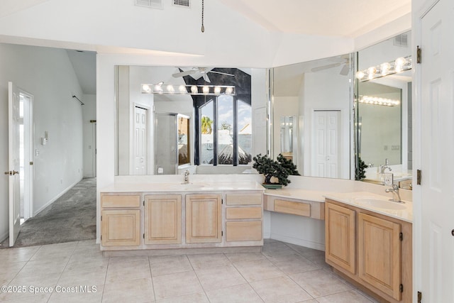 bathroom featuring lofted ceiling, vanity, tile patterned floors, and walk in shower