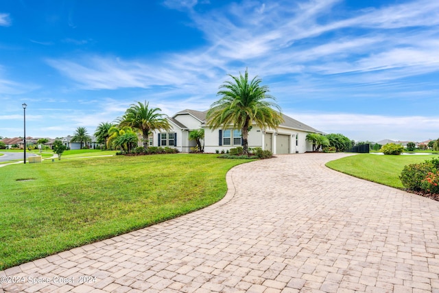 single story home with a garage and a front lawn