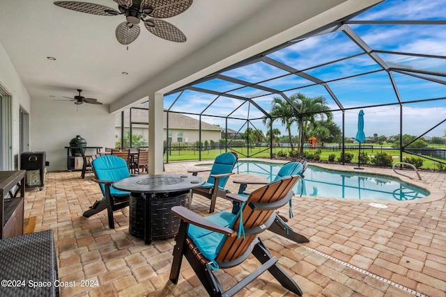 exterior space featuring glass enclosure, a patio area, a bar, and ceiling fan