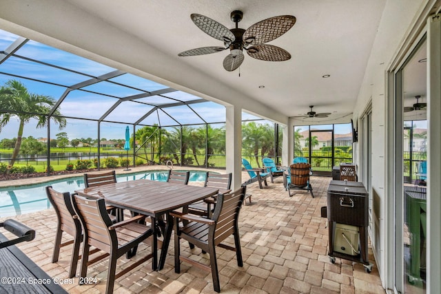 view of patio / terrace featuring ceiling fan and glass enclosure