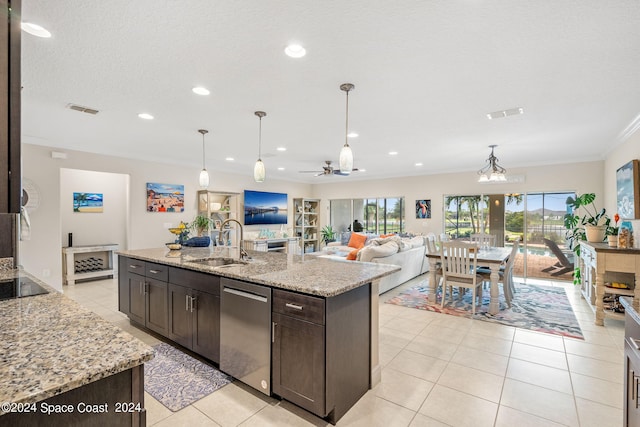 kitchen with light stone countertops, sink, stainless steel dishwasher, and an island with sink