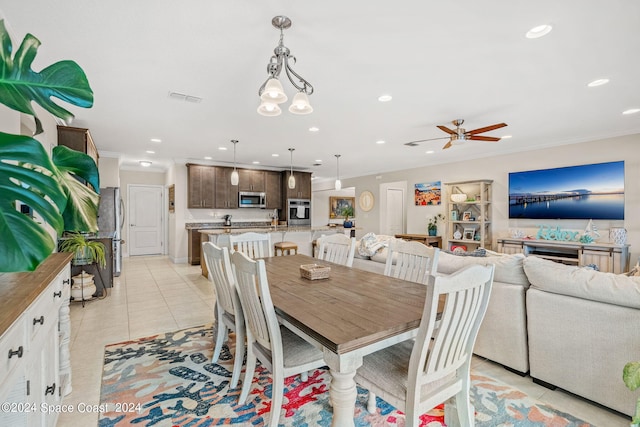 tiled dining room with ceiling fan with notable chandelier