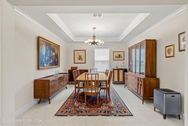 dining area with light tile patterned flooring, a tray ceiling, ornamental molding, a textured ceiling, and a chandelier