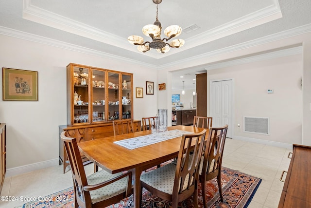 dining area with light tile patterned floors, crown molding, a tray ceiling, and a notable chandelier