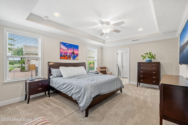 carpeted bedroom featuring a raised ceiling, ceiling fan, and multiple windows