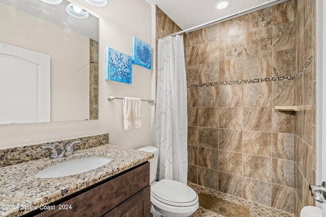 bathroom with toilet, a shower with shower curtain, a textured ceiling, and vanity