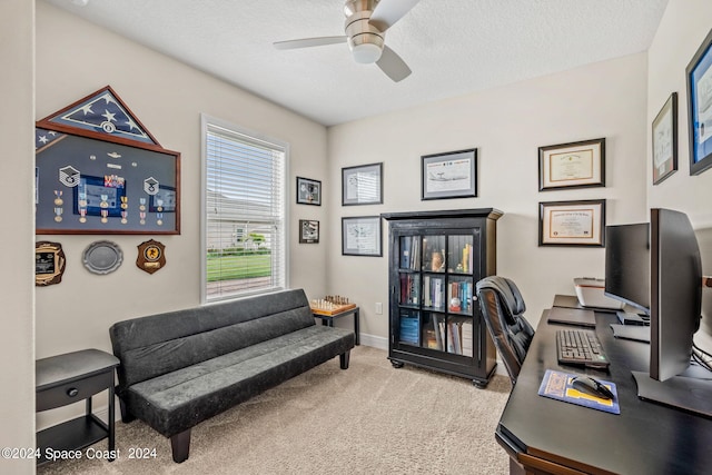 carpeted home office featuring ceiling fan and a textured ceiling