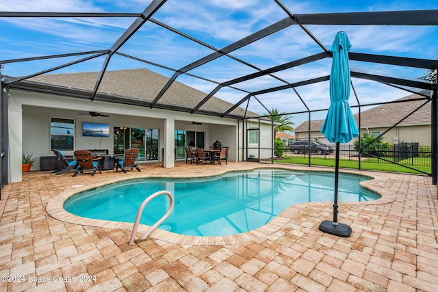 view of swimming pool with a lanai, ceiling fan, and a patio