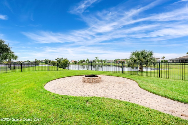 view of yard with a patio area, an outdoor fire pit, and a water view