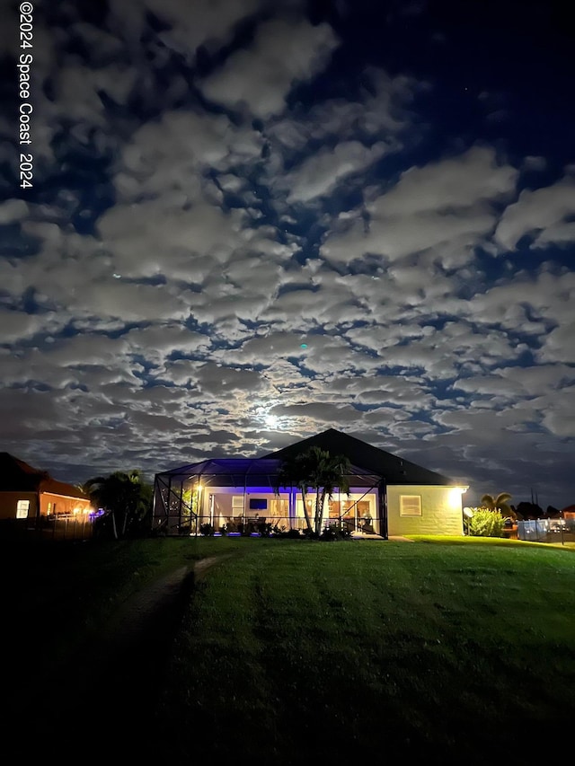 yard at dusk featuring glass enclosure