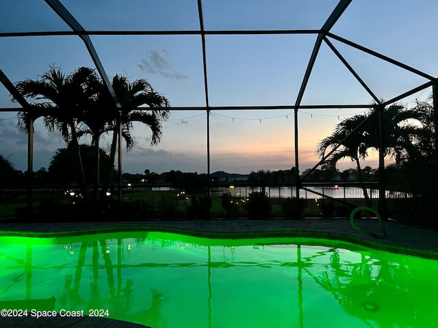 pool at dusk with a lanai