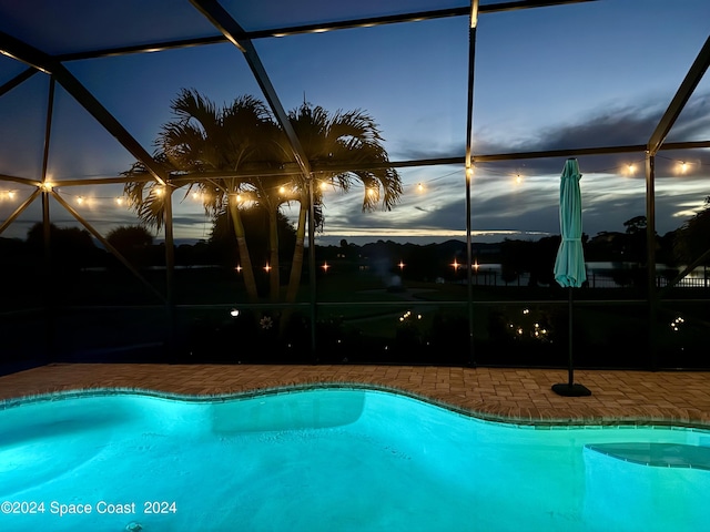 pool at dusk with a lanai