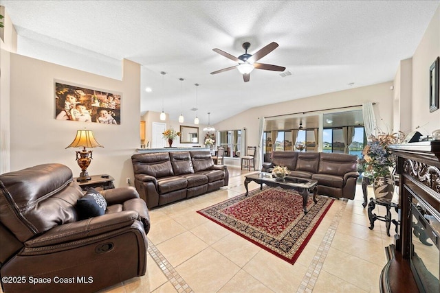 tiled living room with ceiling fan, vaulted ceiling, and a textured ceiling