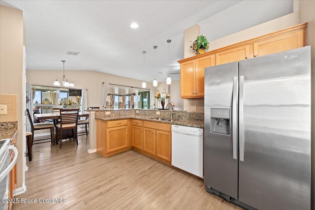 kitchen with sink, dishwasher, stainless steel refrigerator with ice dispenser, decorative light fixtures, and kitchen peninsula