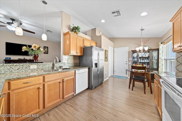 kitchen with stainless steel refrigerator with ice dispenser, sink, range, white dishwasher, and pendant lighting