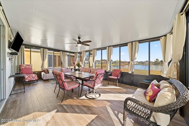 sunroom featuring a water view and ceiling fan