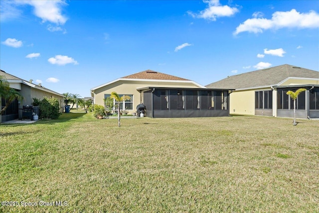 rear view of property featuring a yard and a sunroom