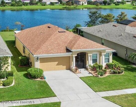 view of front of house with a garage, a water view, and a front yard