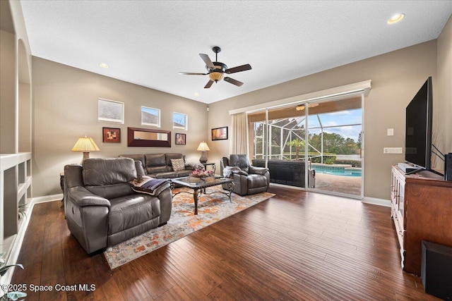 living room with ceiling fan, dark hardwood / wood-style flooring, and a textured ceiling