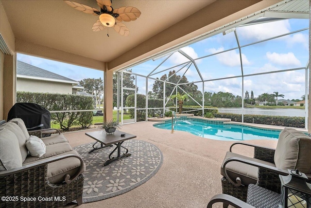 view of pool with glass enclosure, ceiling fan, a grill, a water view, and a patio